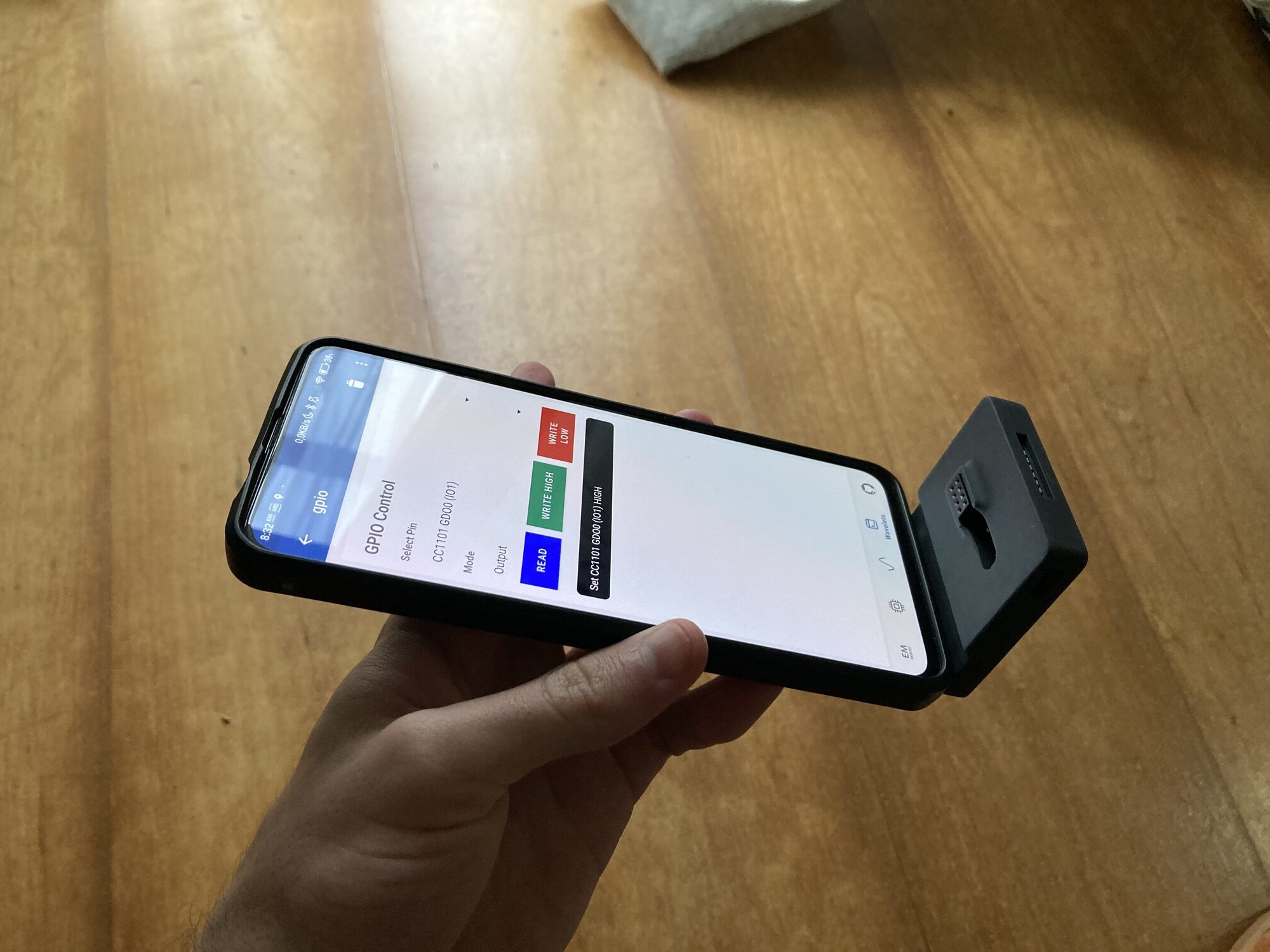 The EMWaver Air in its phone-dock case attached to a smartphone showing the GPIO control panel