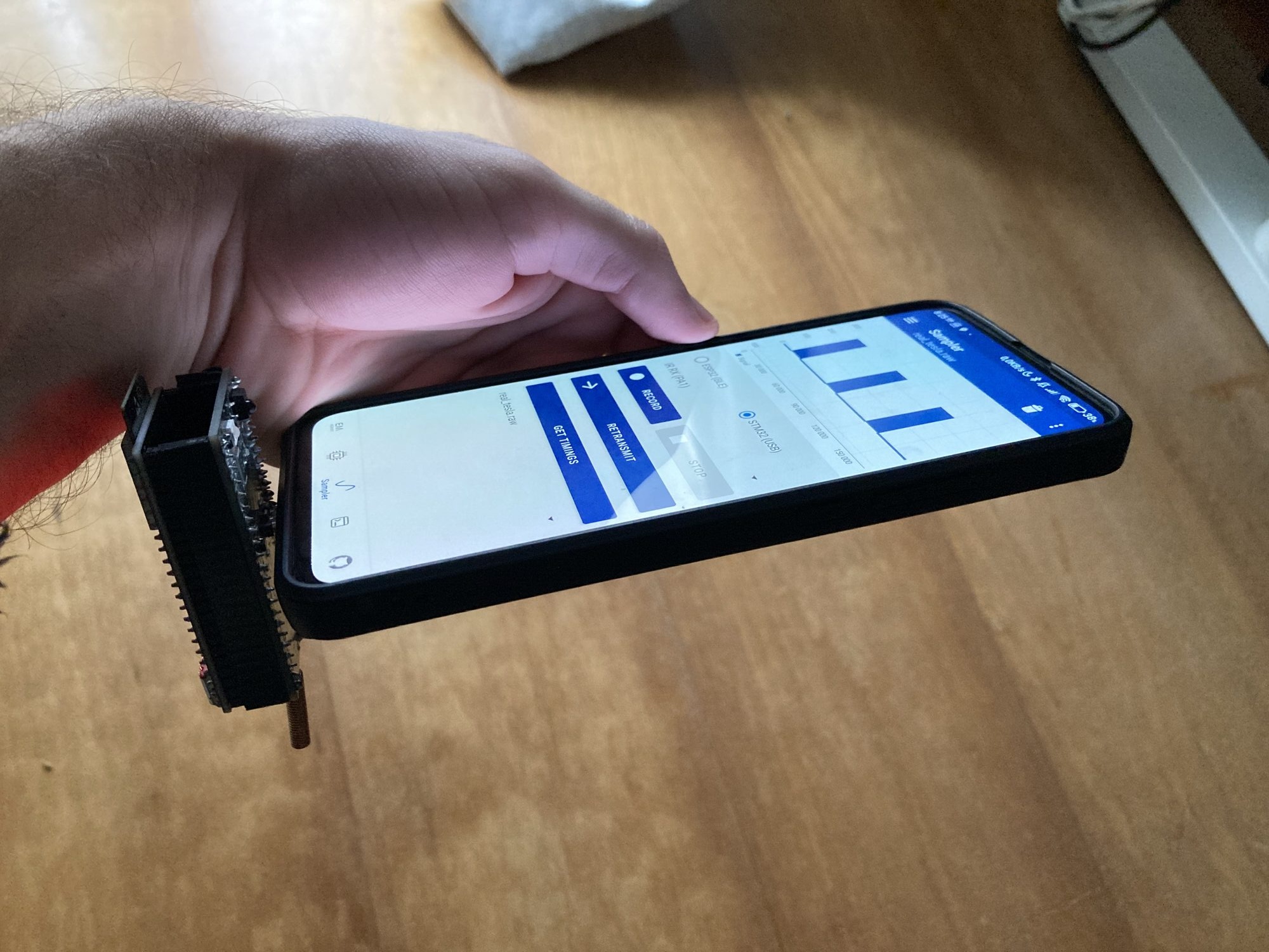 An early prototype board with exposed pin headers plugged into an Android phone running the sampler UI